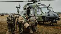 Soldaten tragen einen Verwundeten zu einem Hubschrauber, der zum Transport bereitsteht.