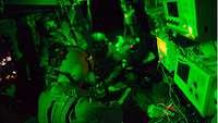 Ein Arzt versorgt einen Verwundeten bei grünem Licht in einem Hubschrauber.