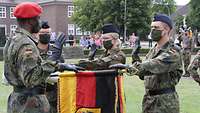 Soldatinnen und Soldaten vor einer Deutschlandflagge