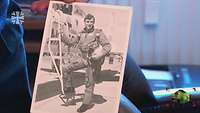 Eine alte Fotoaufnahme von einem Bundeswehr-Piloten, der mit einem Helm unter dem Arm an einem Flugzeug steht