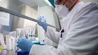 Ein Laborwissenschaftler hält eine Pipette und ein Reagenzglas