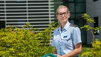 Die Soldatin Madeleine#fr Bojer trägt eine blaue Luftwaffenuniform und hat ein französisches Lehrbuch in der Hand.