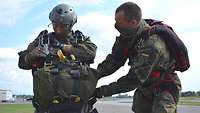 Ein Soldat überprüft die Fallschirmspringer-Ausrüstung seines Kameraden.