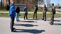 Eine Gruppe von Reservistendienst Leistenden stehen mit dem Kommandeur in einem Kreis.