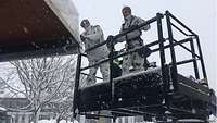 Soldaten räumen Schneemassen von einem Dach