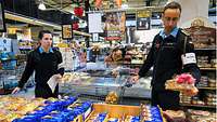 Zwei Marinesoldaten in blauer Arbeitsuniform in einem Supermarkt