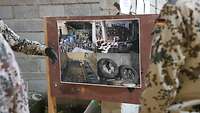 Schautafel mit Fotos aus einer Sprengfallenwerkstatt