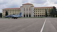 Das Hauptgebäude der École de l’air, davor steht ein französisches Kampfflugzeug vom Typ Mirage 2000B.