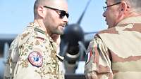 Oberstleutnant A. Braun spricht mit einem französischen Soldaten. Im Hintergrund ist eine KC-130J zu sehen.