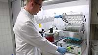 Ein Chemisch-technischer Assisten bedient ein Laborgerät