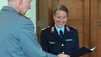 Birgit Czernotzky bekommt vom Kommandeur der Führungsakademie die Urkunde zum Oberst der Reserve ausgehändigt 
