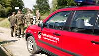 Soldaten stehen hinter einem Fahrzeug des Katastrophenschutzes aus dem Landkreis Wittenberg.