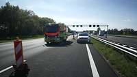 Ein Rettungswagen und ein niederländisches Polizeiauto sperren eine Autobahn