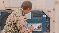 Eine Soldatin prüft die Temperatur auf der Anzeige eines Kühlcontainers