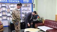 Ein Soldat mit einem Mitarbeiter des Bawar Media Centers im Büro
