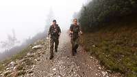 Zwei Soldaten wandern in den Alpen