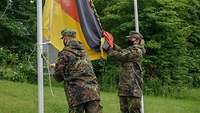 Zwei Soldaten hissen die Bundesdienstflagge