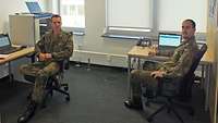 Zwei Soldaten sitzen in einem Raum vor Laptops bei der Übung CWIX 2020.