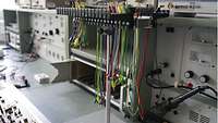 Elektronische Prüfgeräte und bunte Kabelstränge füllen die Elektroniker-Werkstatt.