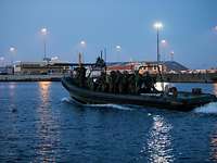  Soldaten fahren bei Nacht mit einem Schlauchboot zum einen Sammelpunkt im Hafen