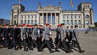 Soldaten in Marschordnung, dahinter das Reichstagsgebäude 