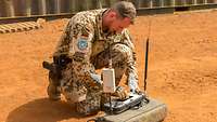 Ein Soldat putzt mit einem Tuch das Display vom Bedienteil für die MIKADO