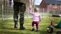 Soldat geht mit Kind an der Hand