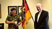 Brigadegeneral Andreas Henne und Militärbischof Franz-Josef Overbeck vor der Deutschlandfahne in der Julius-Leber-Kaserne Berlin