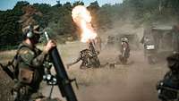 Soldaten schießen aus drei Feuerstellungen auf einem Feld mit ihren Mörsern, ein Feuerball entsteht.