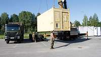 Der Container mit dem mobilen Labor für Flugkraftstoffe wird auf der Ämari Air Base in Estland durch einen Kran aufgestellt.