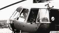 Schwarzweiß-Aufnahme von einem Hubschrauber, in dem zwei Bundeswehr-Piloten im Cockpit sitzen