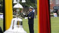 Ein Soldat dirigiert ein Orchester auf dem Appellplatz.