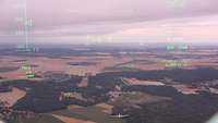 Durch das Head-Up-Display des A400M sieht man die Landschaft um Paris und ein anderes Flugzeug.