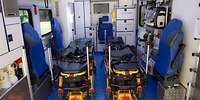 Blick in den Patientenraum eines Intensivtransportwagens, in dem zwei Rettungstragen ohne Patienten festgemacht sind