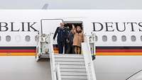 Oberst Daniel Draken und Judith Urban stehen oben auf der Treppe des gerade gelandeten A340 der Flugbereitschaft.