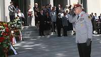 Generalleutnant Fritz salutiert vor den Kränzen