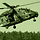 An NH90 helicopter hovers closely above a field.