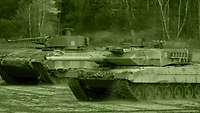 A Leopard 2 MBT traverses open ground alongside a Marder IFV.