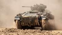 A Marder IFV vehicle traverses dusty terrain.