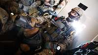 A military working dog serving with SOF sits in front of his handler on board an aircraft.