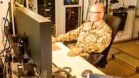 Hauptmann Hendrik M. sitzt an seinem Schreibtisch und arbeitet am Computer