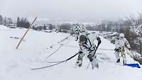 Soldaten schaufeln Schnee von einem Dach