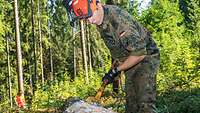 Ein Soldat arbeitet mit einem Schäleisen 