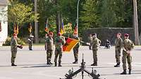 Ein Soldat befestigt das Fahnenband an der neuen Truppenfahne.