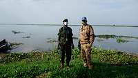 Ein Militärbeobachter steht mit einem südsudanesischen Verbindungsoffizier am Ufer des Nils