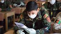 Ein afghanischer Soldat schaut auf ein Papier, das er in der Hand hält