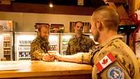 Zwei Soldaten an einer Bar-Theke beim Verkauf von Kaffee
