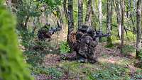 Soldaten knien im offenen Wald beim Ausweichschießen.