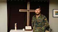 Der Militärseelsorger steht im Feldanzug vor dem Altar der Kirche „Little Church“