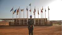 Major Christine Mendy steht vor den Flaggen des Camp Castor in Gao, Mali. 